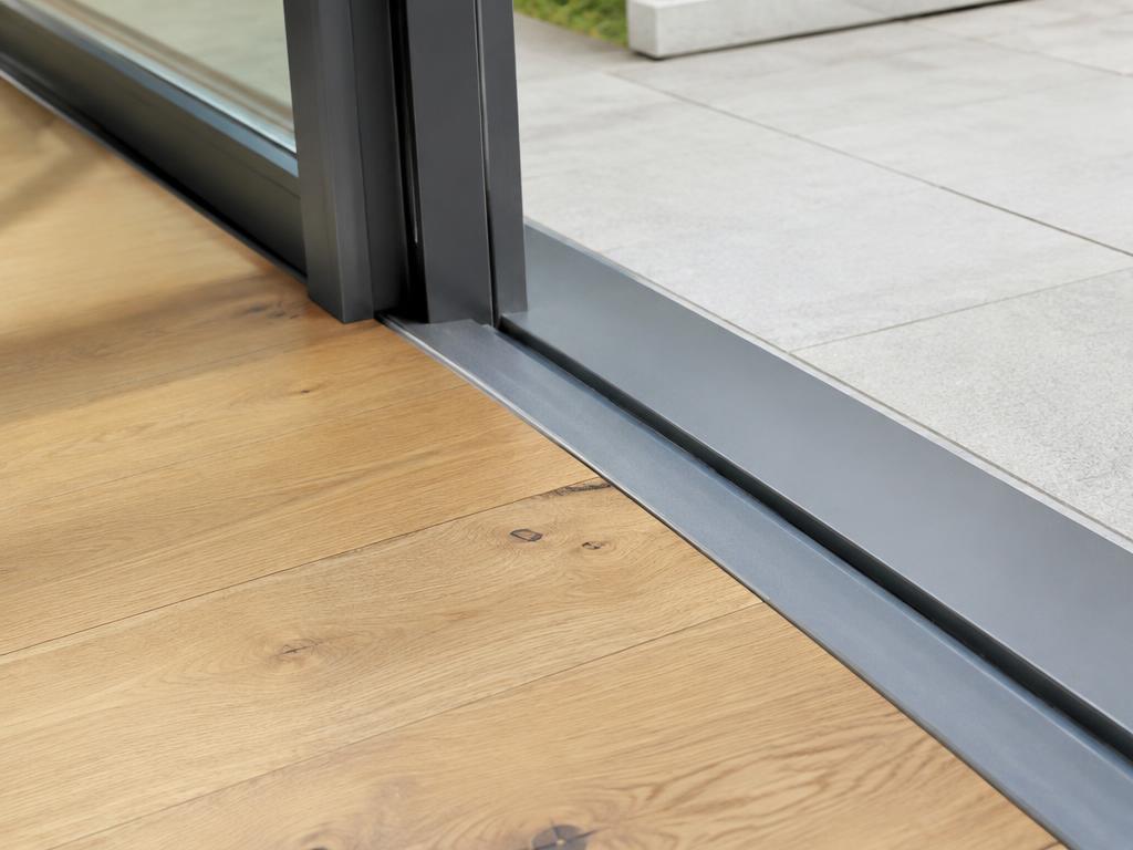 Flush door threshold between oak floor and patio